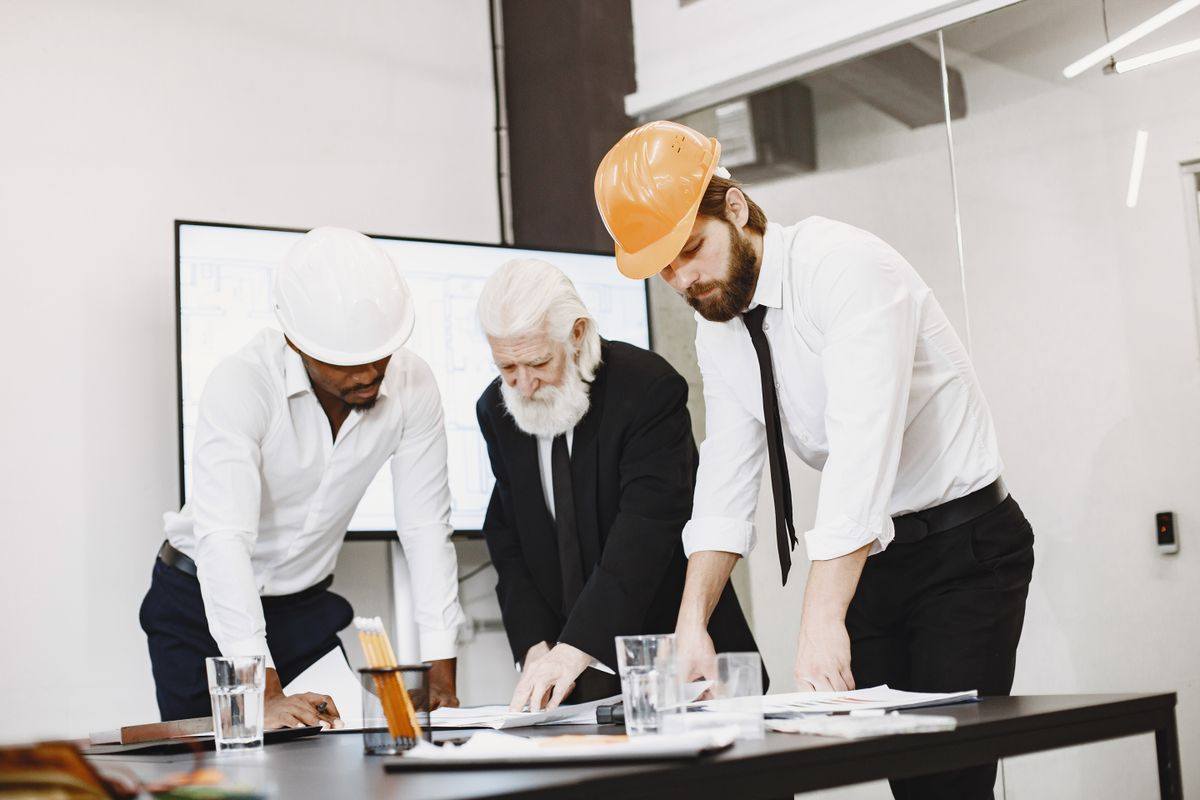 Construction and engineering professionals reviewing blueprints in an office