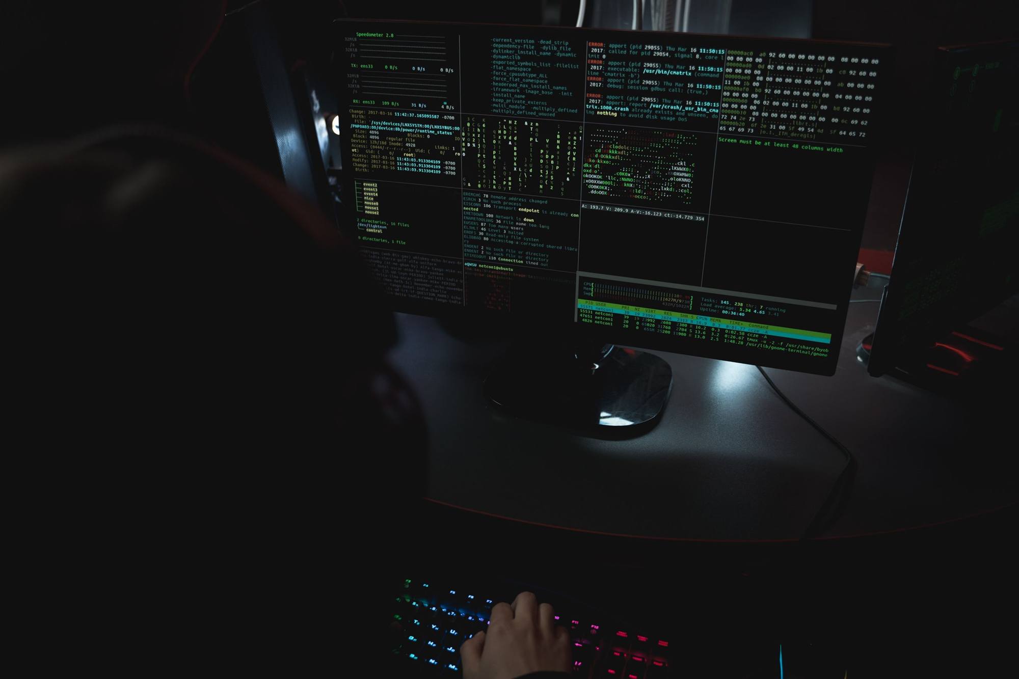 IT security analyst monitoring network activity on multiple screens