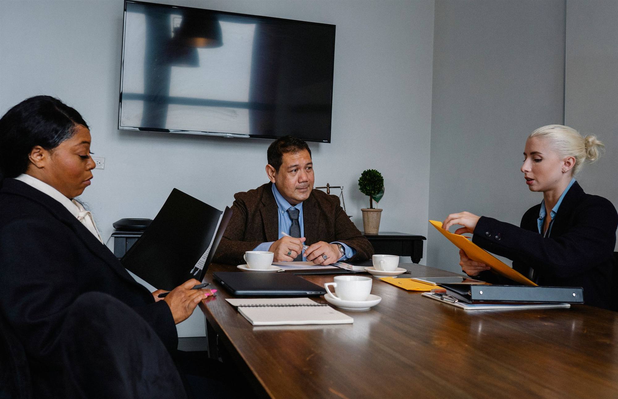 Team reviewing cybersecurity compliance documents in an office meeting