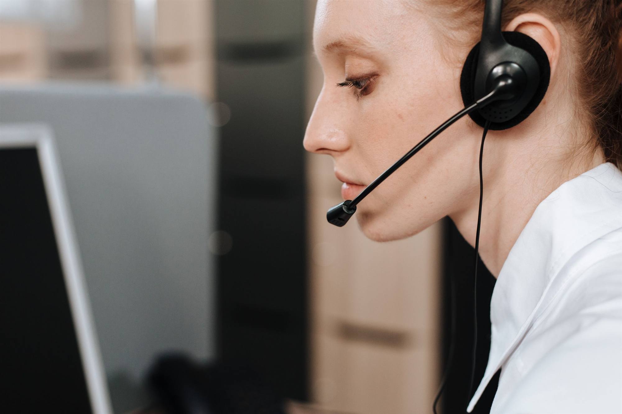 Helpdesk support agent wearing a headset assisting a client