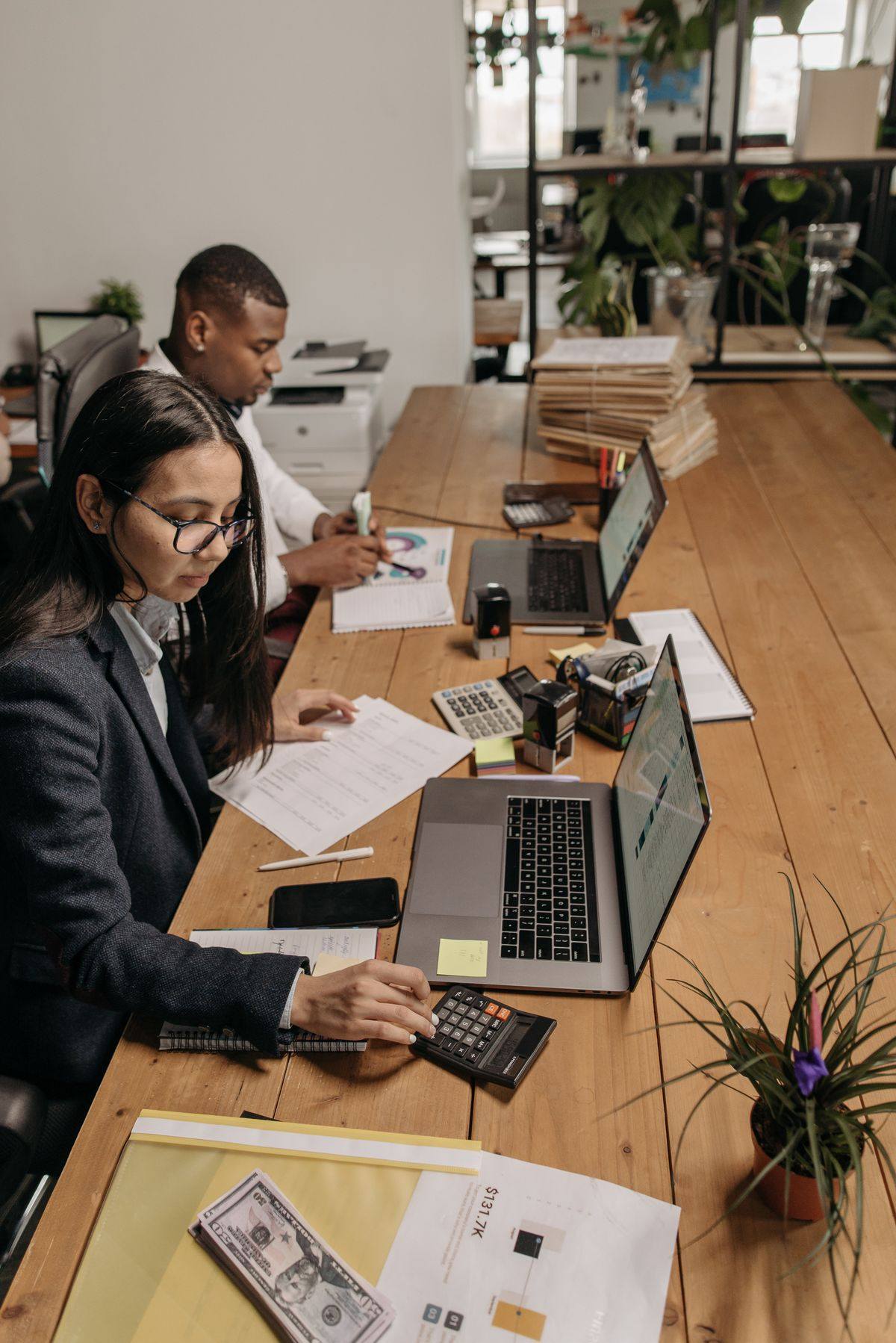 Accounting professionals working with laptops and a calculator, IT helpdesk support for accounting firms in Scarborough