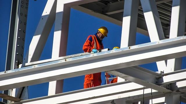 Construction worker on structural steel beams at a jobsite, managed IT support for construction firms